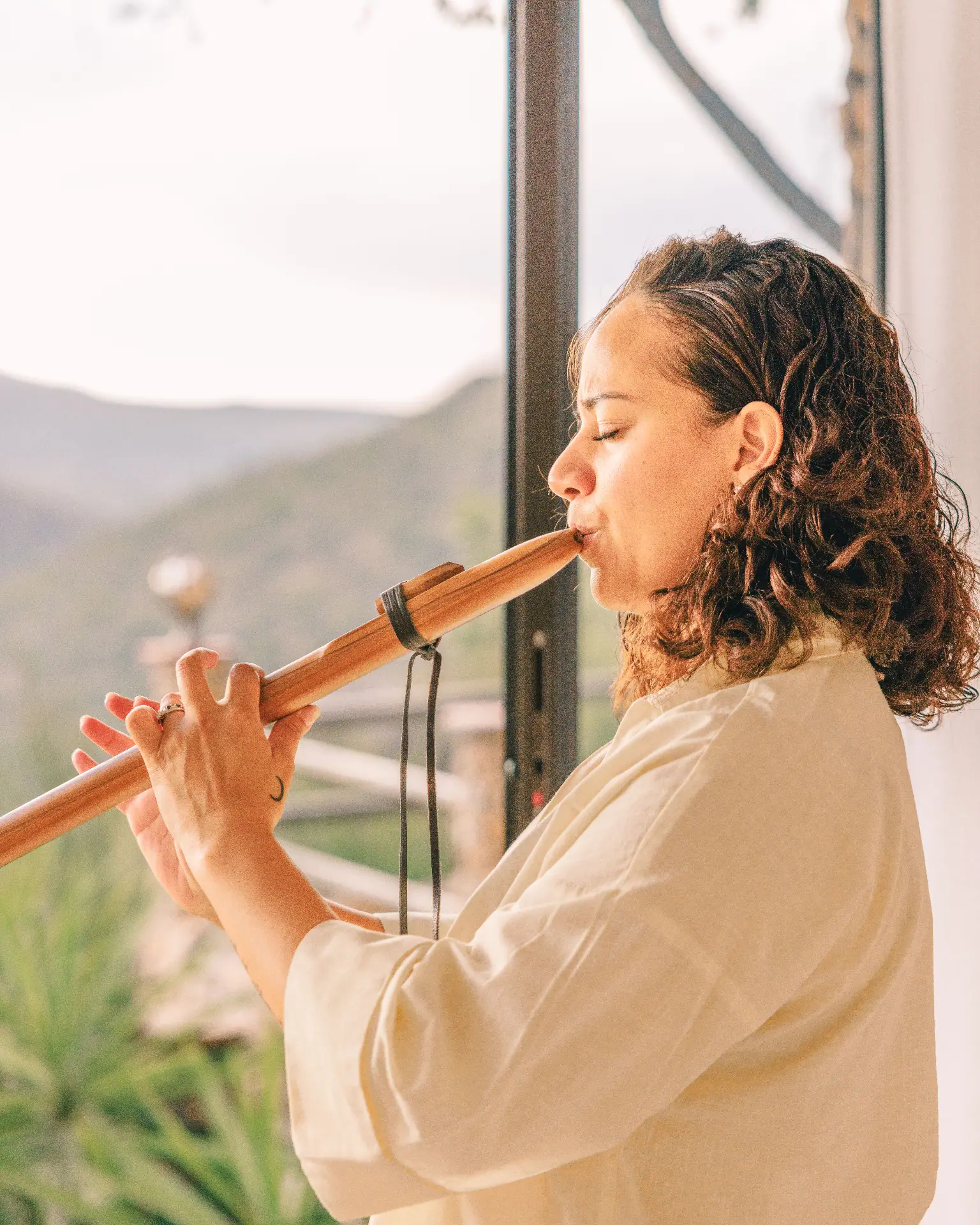 Practitioner playing a wooden flute at sunrise